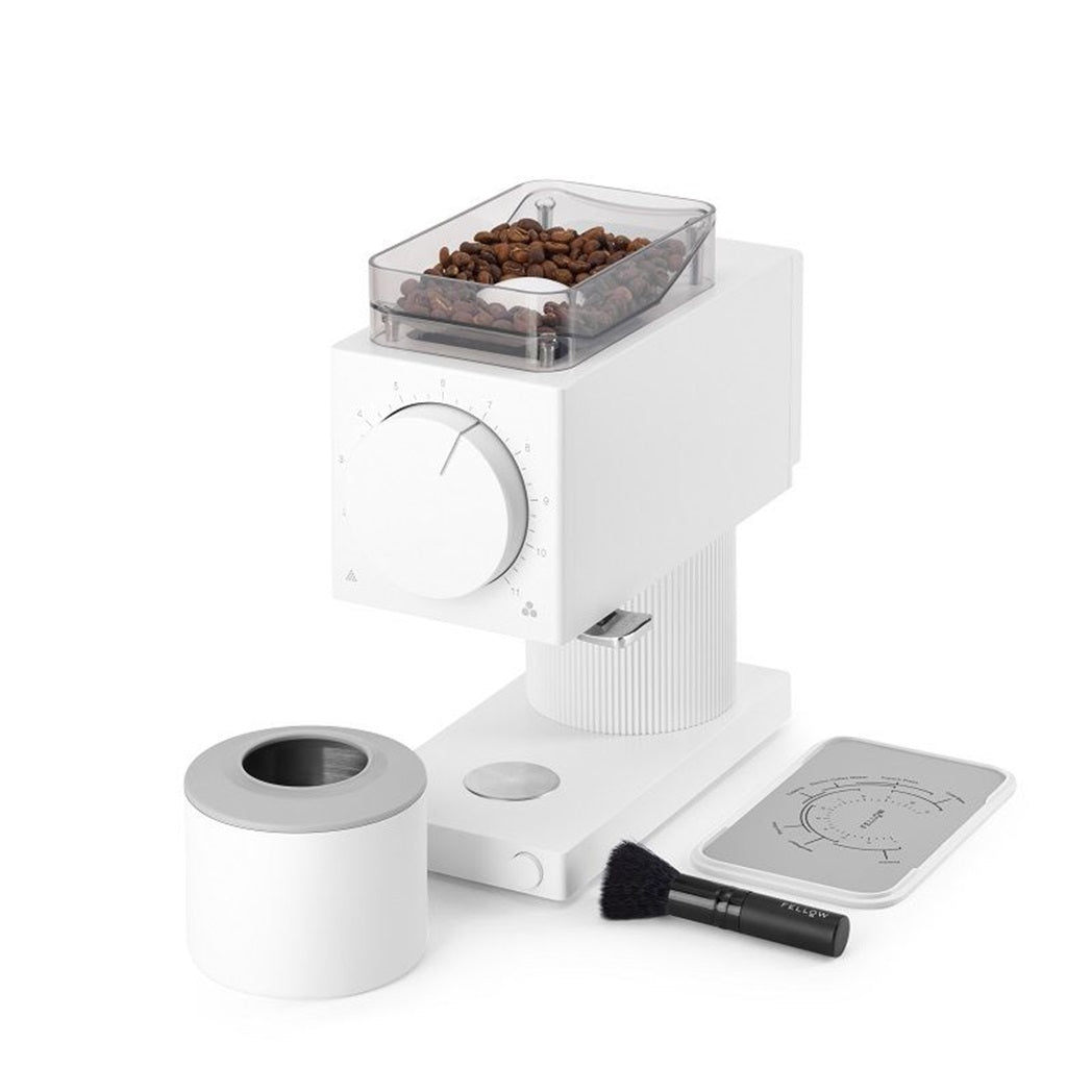 Fellow Gen 2 Coffee Grinder filled with coffee beans, lid off and next to cleaning brush