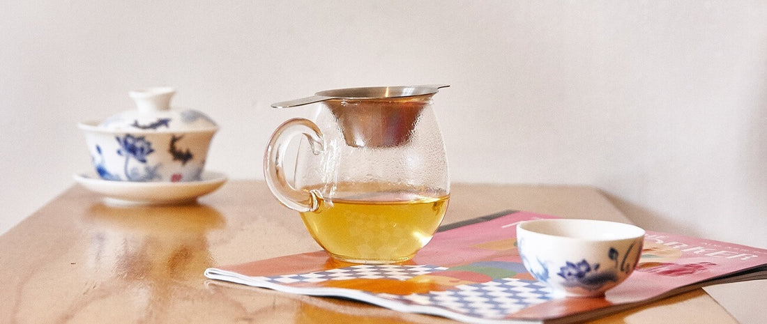 Green tea on magazine and next to chinese tea cup