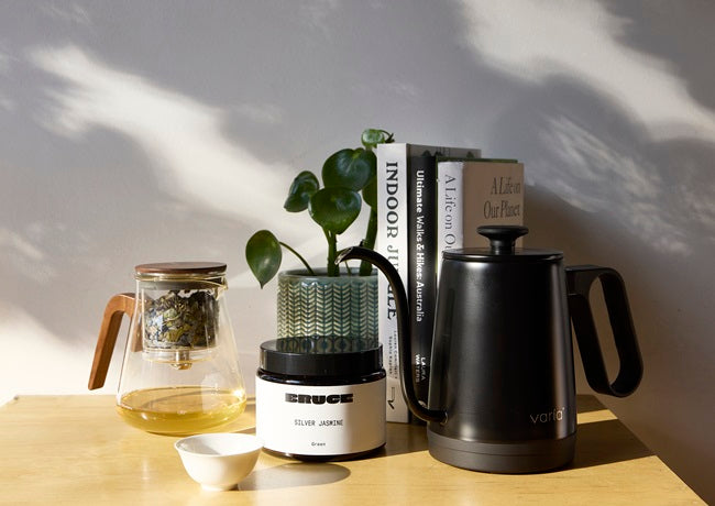 Silver Jasmine tea next to tea infuser and gooseneck kettle